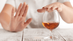a woman putting her hand up saying no to alcohol for IBS